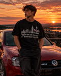 Front of the black British time tee on a model at sunset, with a white line drawing of Westminster, a lamp post and two Union flags above the slogan